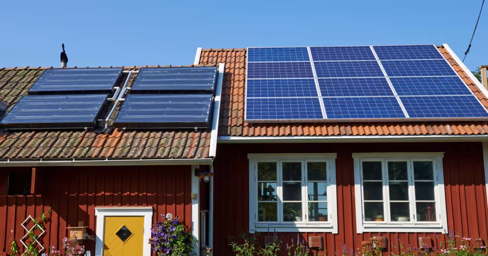 Panneaux solaires sur le toit d'un cottage rouge (Suède)