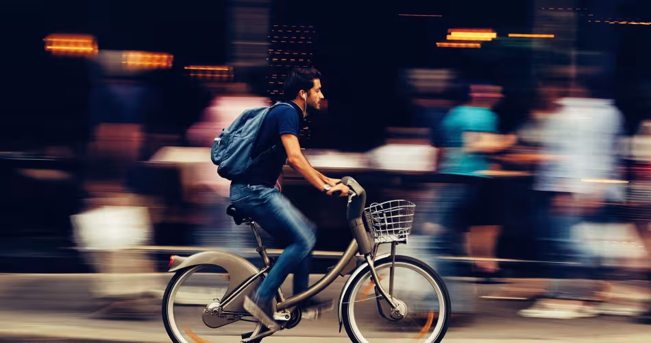 Un homme utilise un vélo partagé en ville pour se déplacer, Paris, France