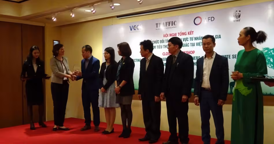 Une représentante du projet remettant une récompense aux dirigeants qui ont activement encouragé leurs personnels à ne pas utiliser de cornes de rhinocéros (Vietnam)