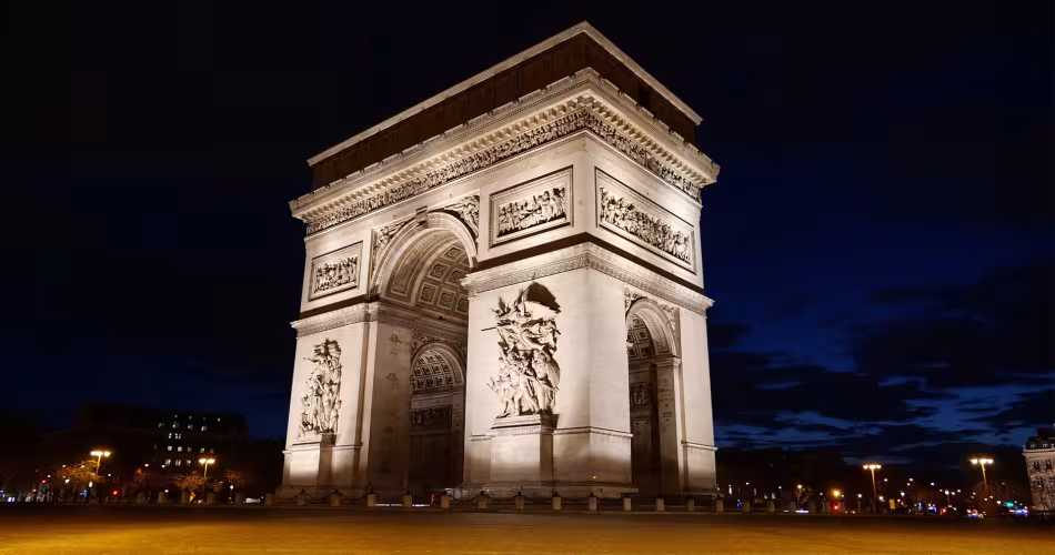 L'arc de triomphe est allumé en pleine nuit.