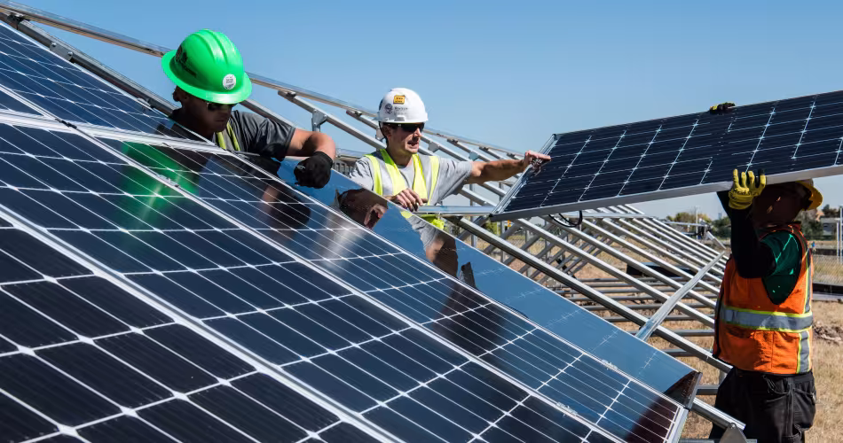 Trois hommes installent des panneaux solaires