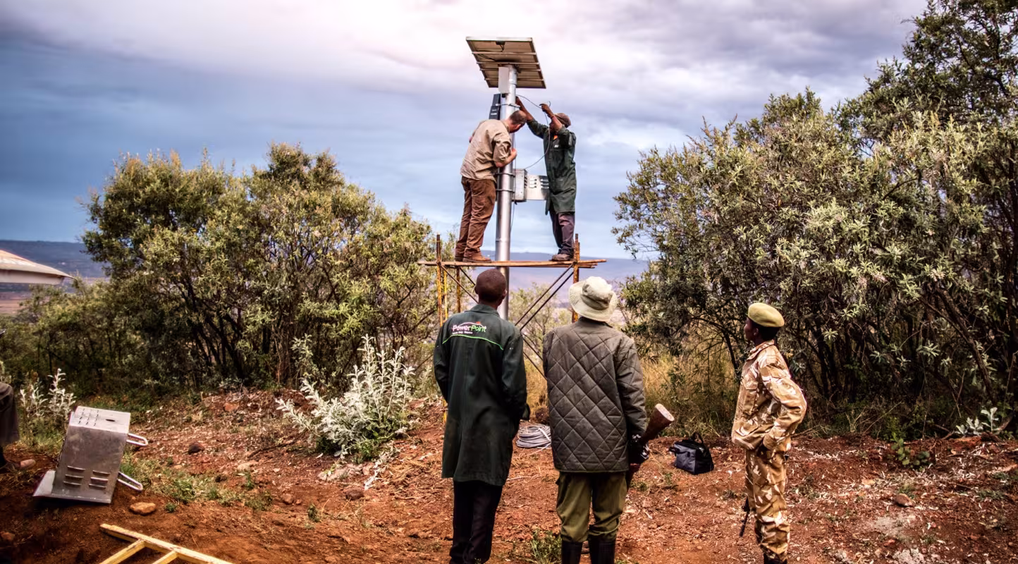 Des ingénieurs installant des panneaux solaires sur une caméra thermique FLIR pour lutter contre le braconnage des éléphants (Kenya)