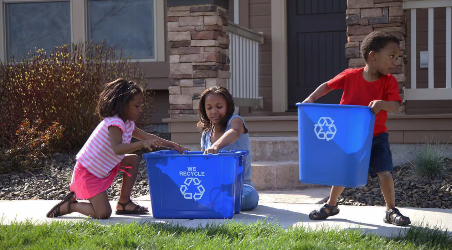Enfants avec des bacs de recyclage des déchets 