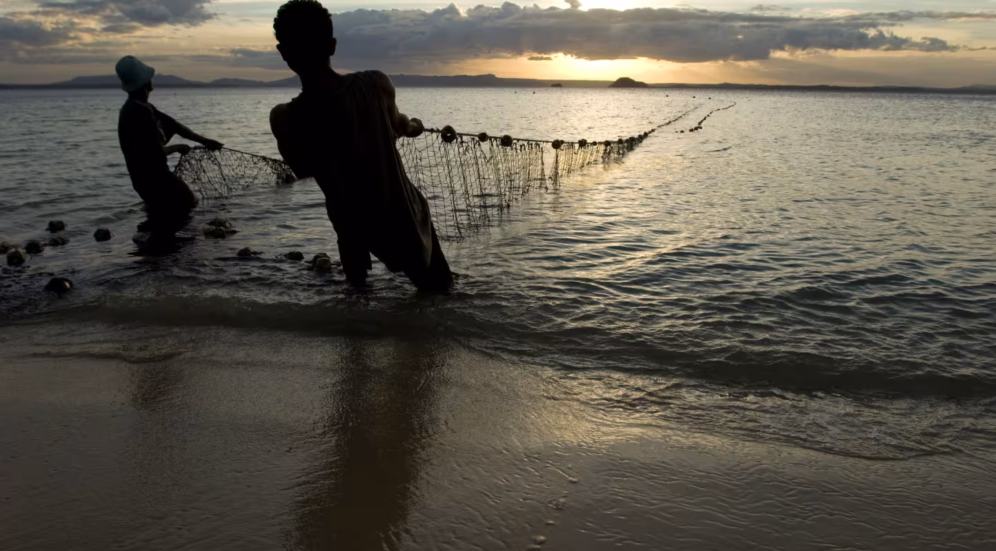 Des pêcheurs sortent leurs filets de l'eau au crépuscule, plage de Ramena à Antsiranana, Nord de Madagascar
