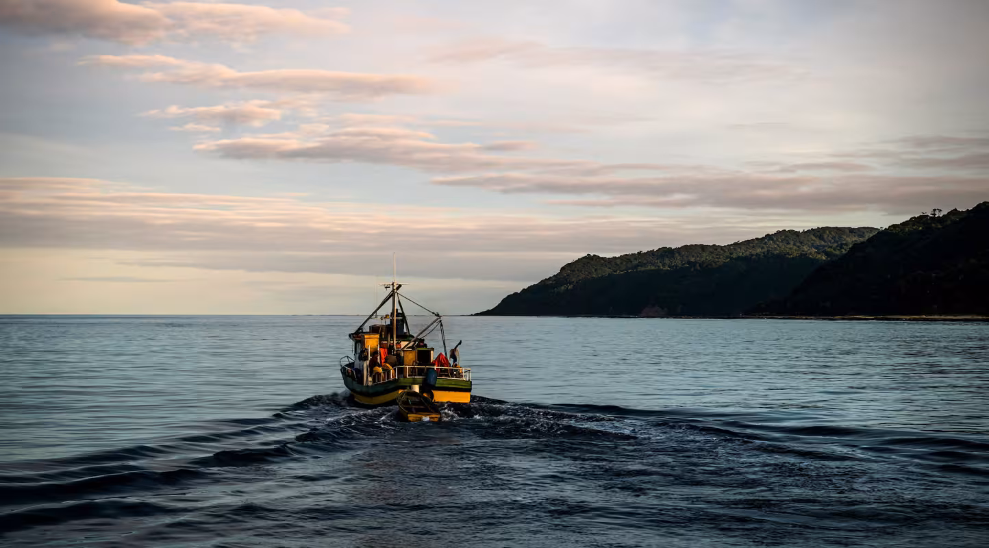 Bateau de pêche artisanal qui navigue au coucher du soleil