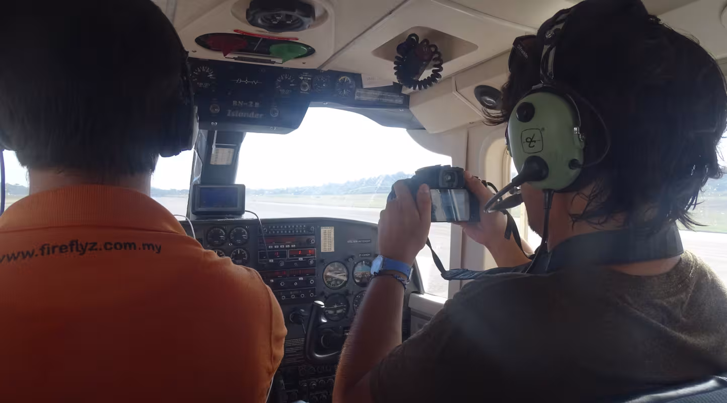 Deux personnes dans un hélicoptère faisant un inventaire aérien pour repérer des dauphins de Guyane