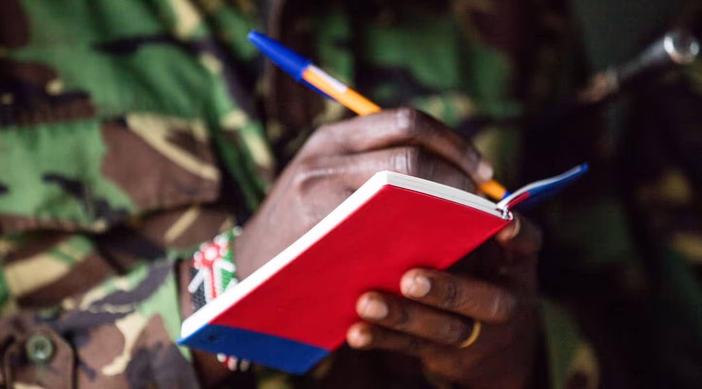 Ranger prenant des notes dans le cadre d'une formation WWF sur la caméra thermique FLIR pour lutter contre le braconnage des éléphants, Réserve nationale de Maasai Mara (Kenya)