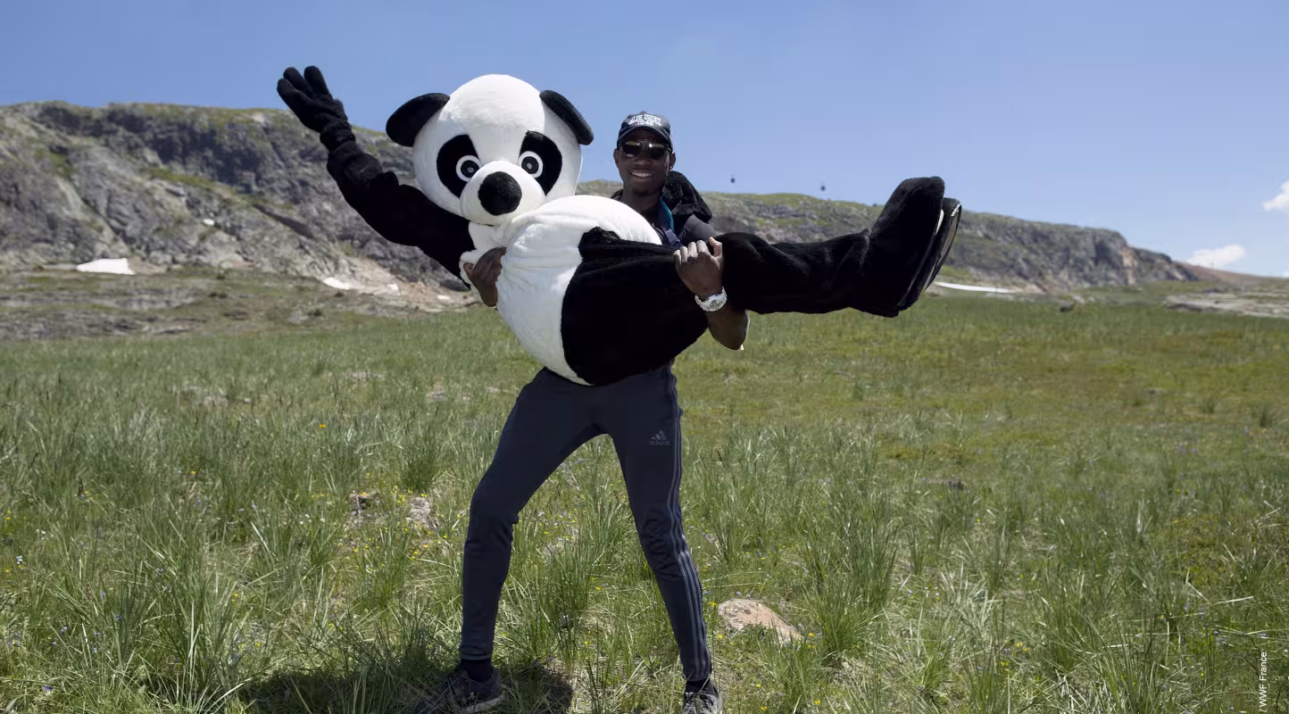Le Panda, mascotte du Pandathlon, dans les bras d'un pandathlète pendant la course d'orientation à l'Alpe d'Huez (France)