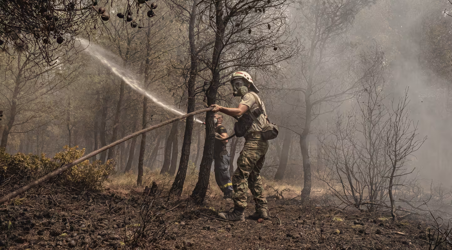 Un pompier qui jette de l'eau pour tenter d'éteindre les flammes