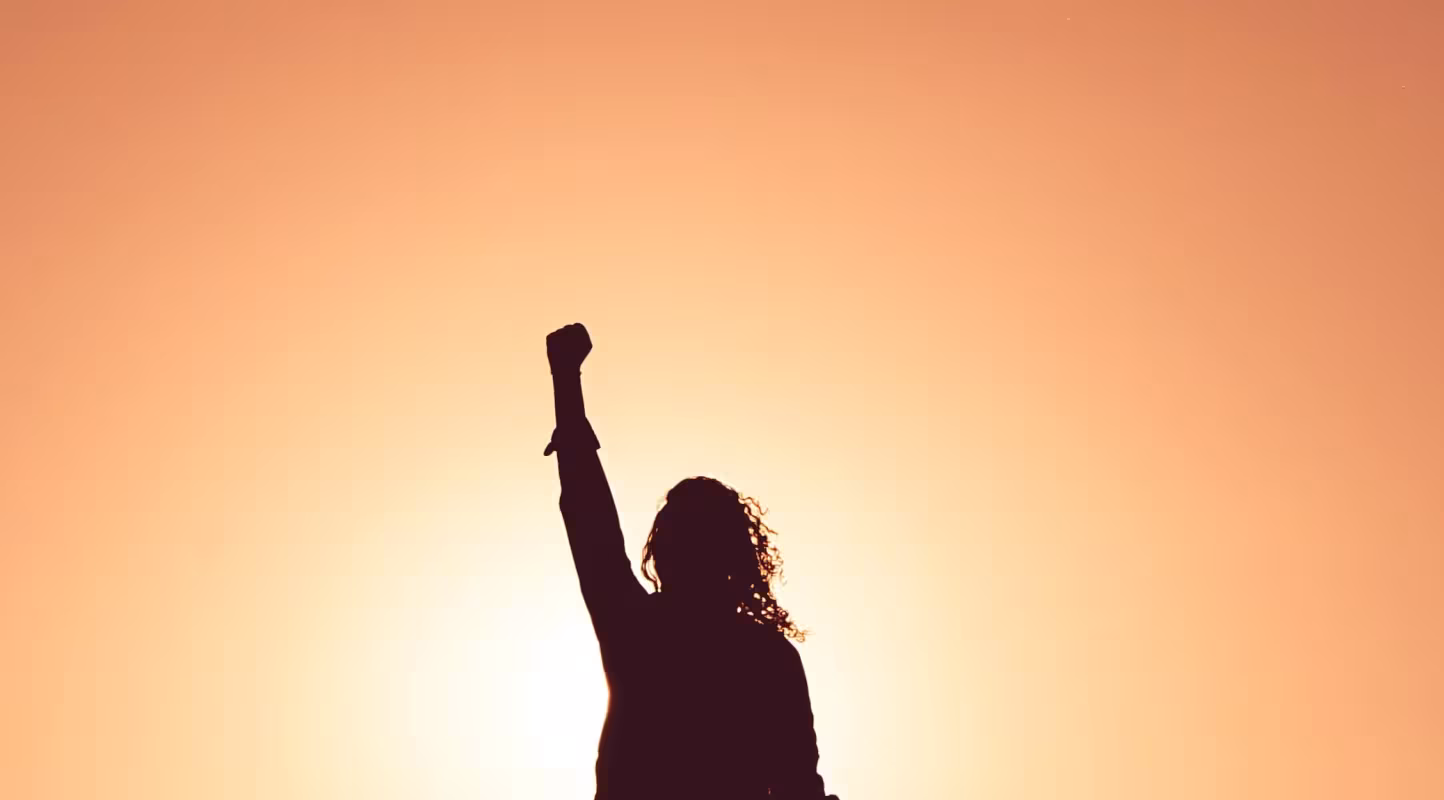 Femme qui lève le point pour montrer son engagement