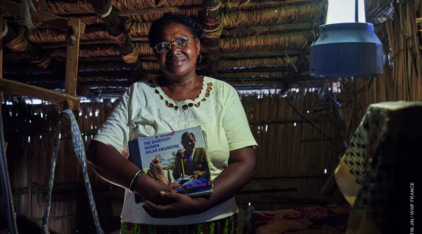 Une grand-mère "solaire"  tient son livre d'apprentissage du barefoot college (Madagascar) 